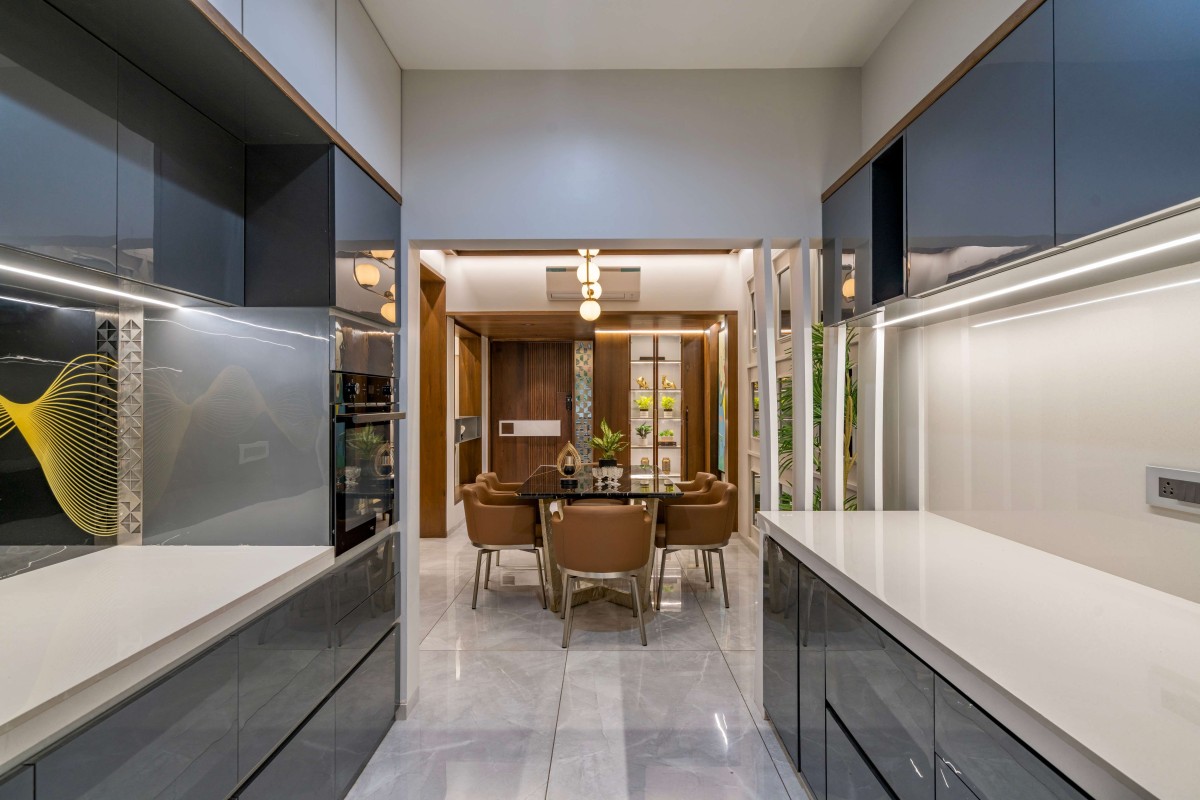 Dining view from kitchen of An Amiable Enclave Of Sharnam 7 by Anand Patel Architects