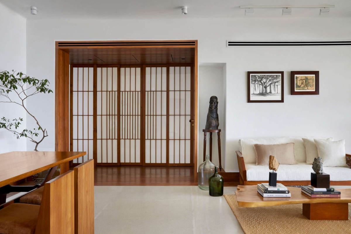 Living room with the pantry doors of The Zen Apartment by Atelier Varun Goyal