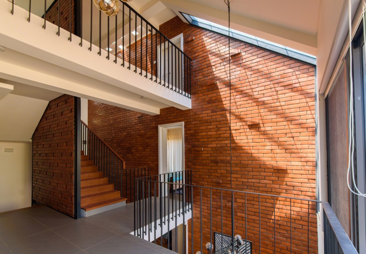 First floor family lounge of Corner Brick House by Jacob + Rathodi Architects
