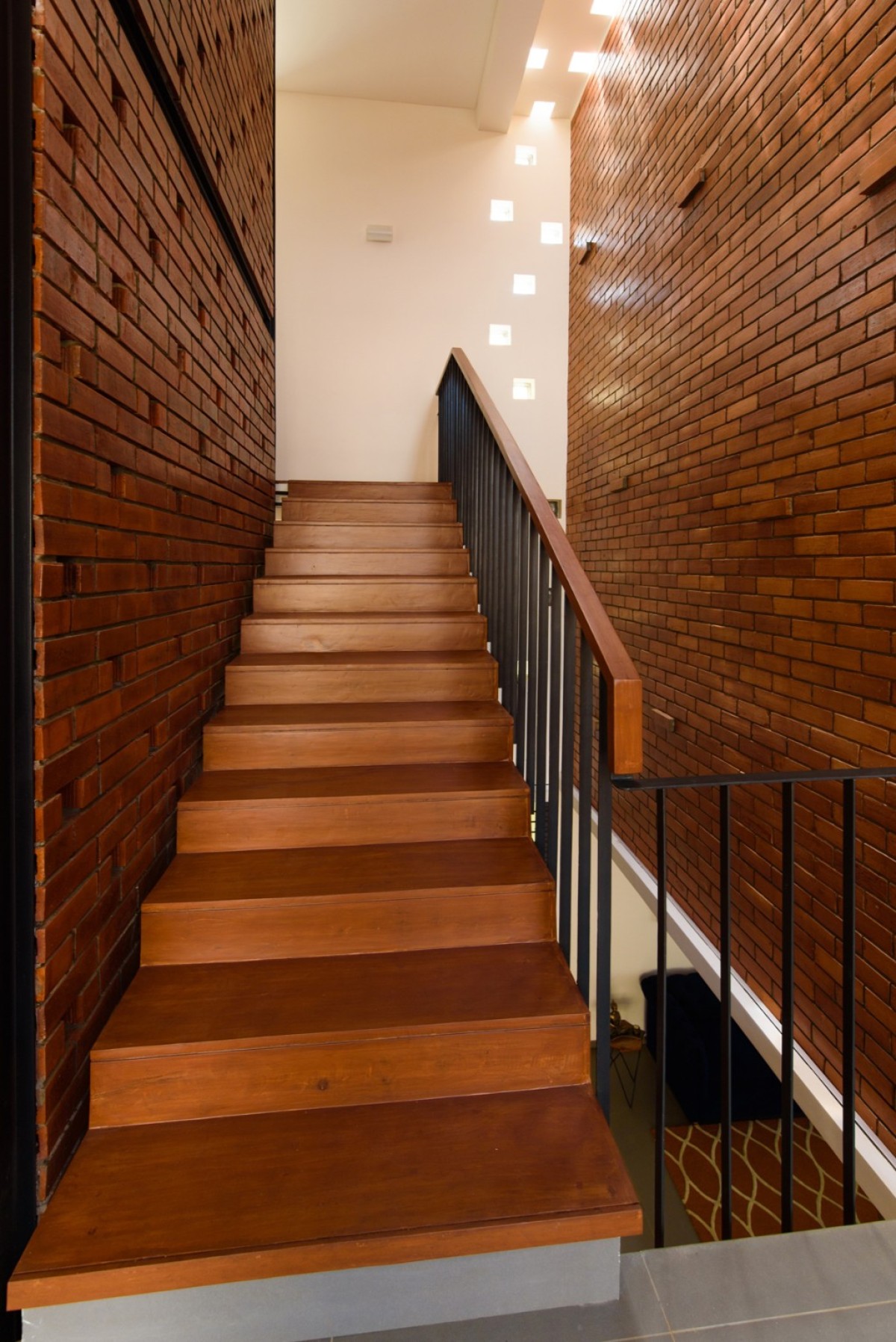 Staircase- from first floor to terrace of Corner Brick House by Jacob + Rathodi Architects