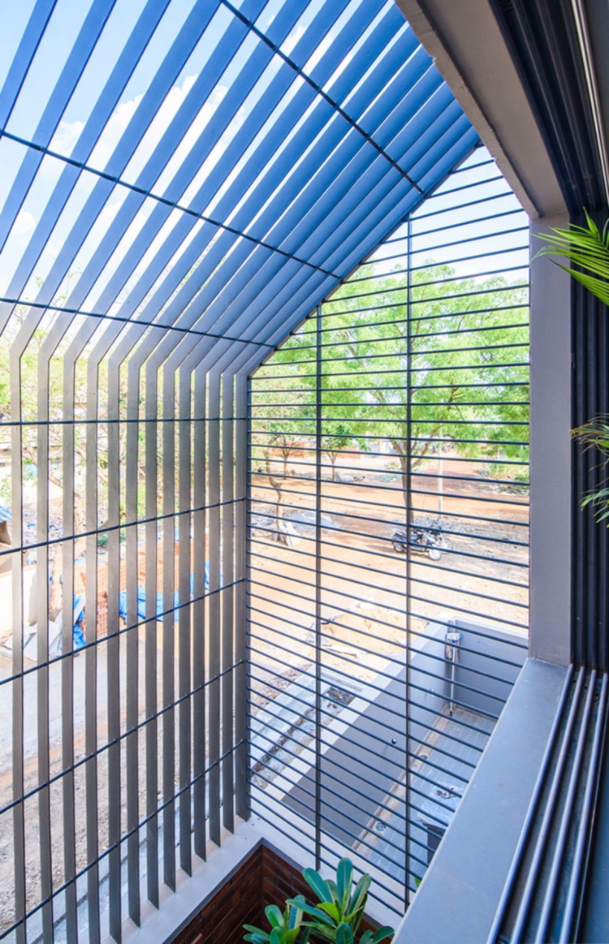 Landscape Courtyard view from 1st floor of Corner Brick House by Jacob + Rathodi Architects
