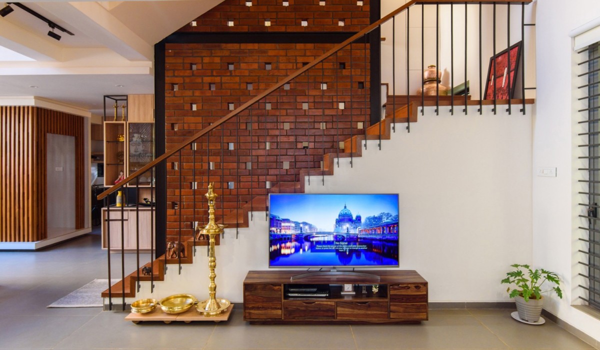 Staircase feature wall backdrops the living room of Corner Brick House by Jacob + Rathodi Architects