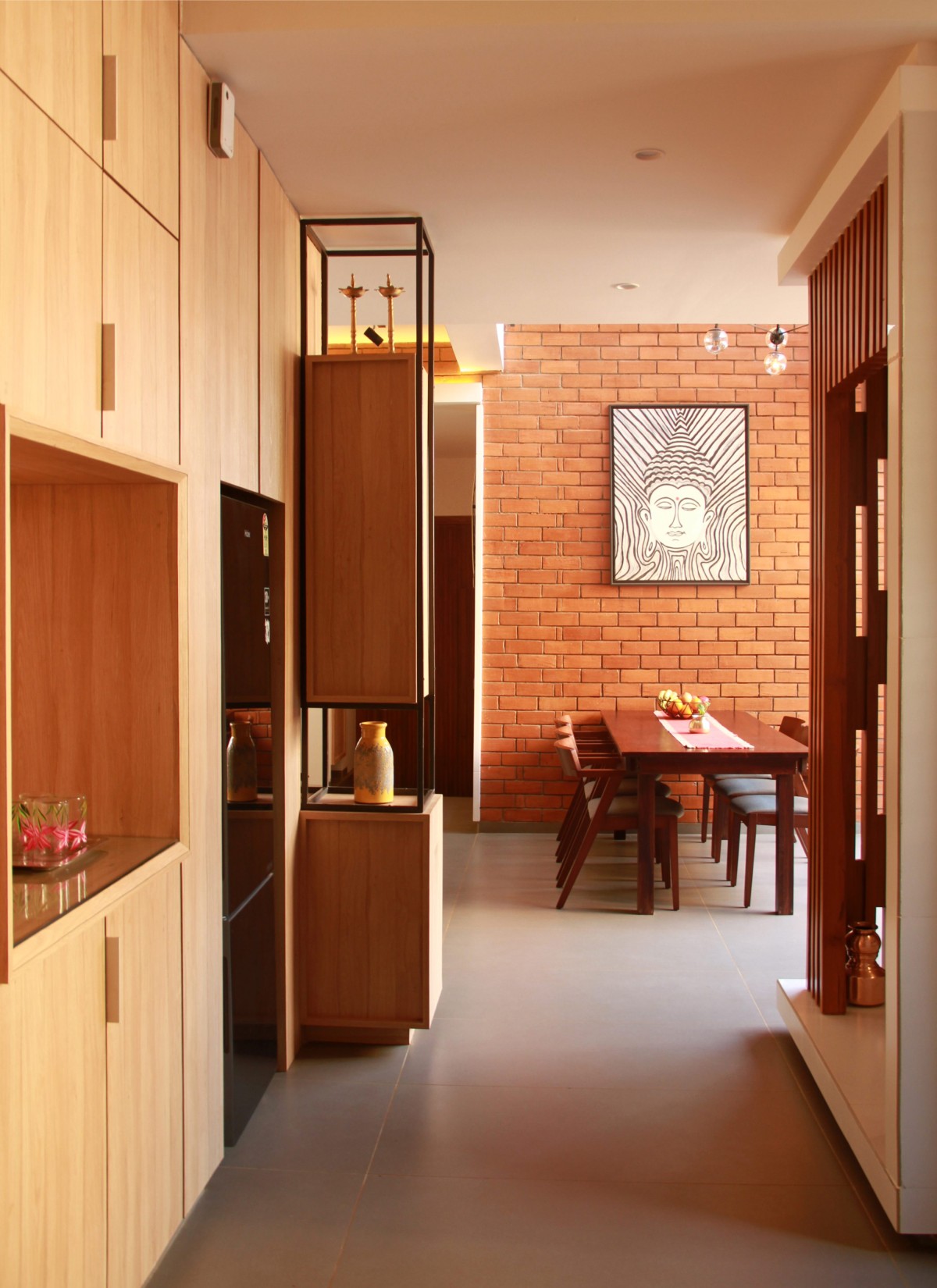 Kitchen to dining of Corner Brick House by Jacob + Rathodi Architects