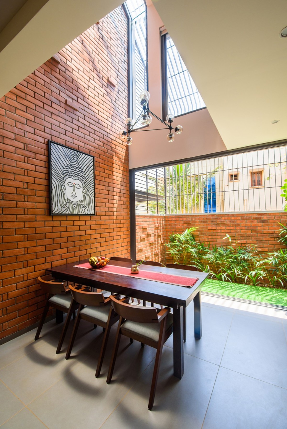 Dining to garden view of Corner Brick House by Jacob + Rathodi Architects