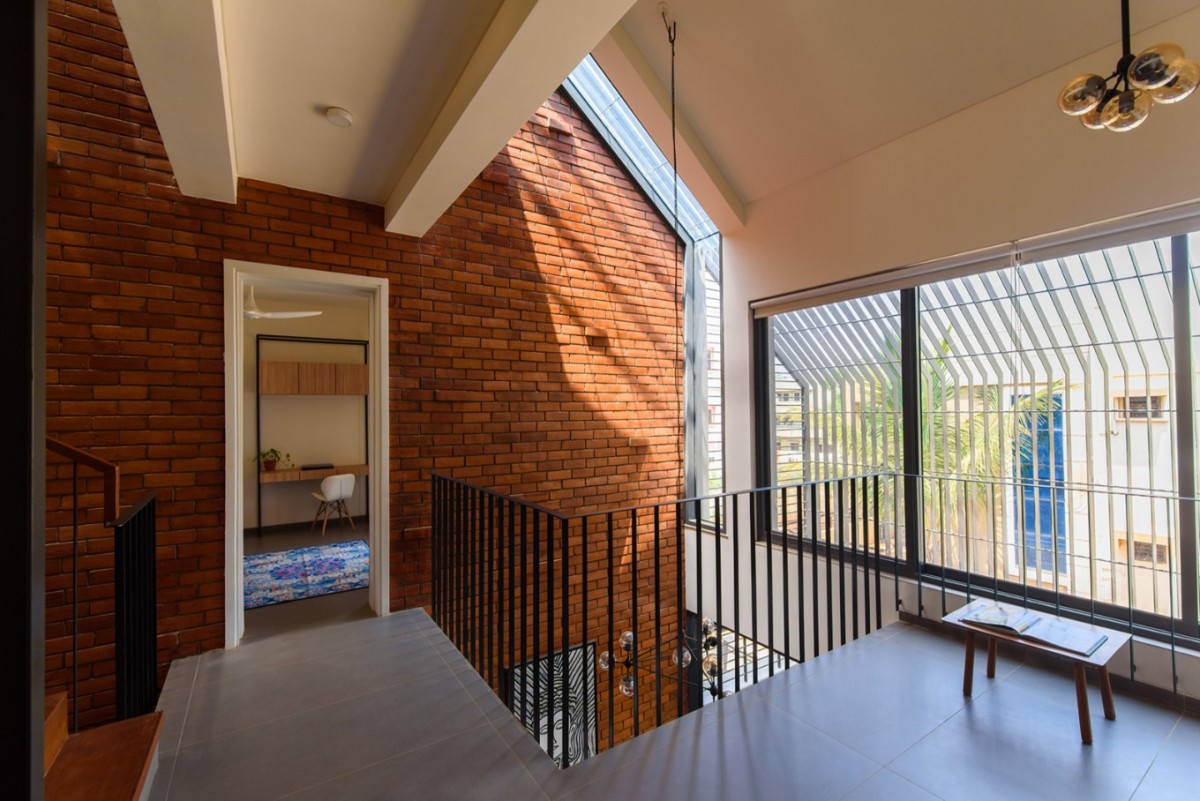 Central void space connecting two bedroom blocks of Corner Brick House by Jacob + Rathodi Architects
