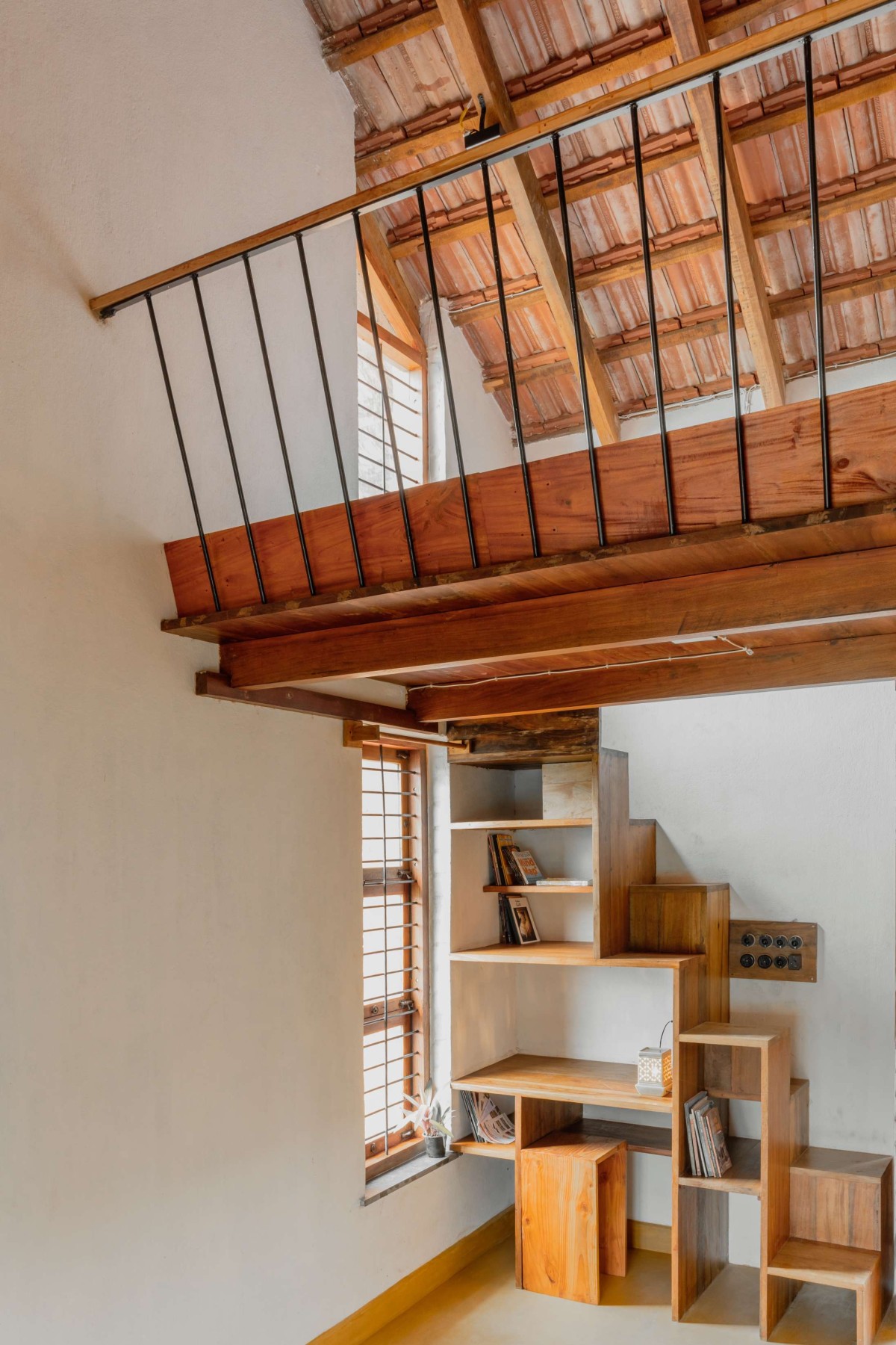 Staircase and Bookshelf of Brick Manor by Bhutha Earthen Architecture Studio
