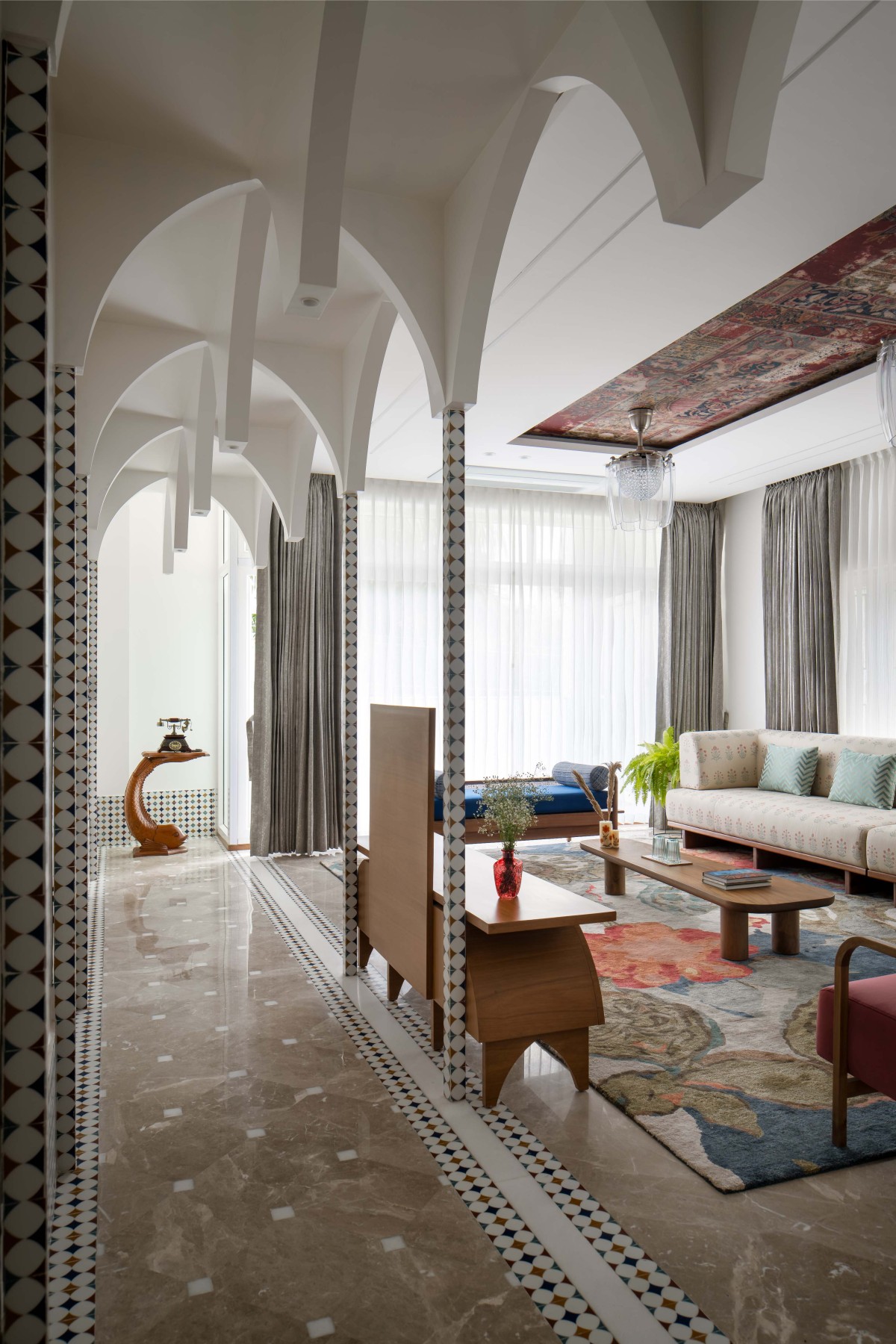 Slim columns, adorned with ceramic tile finishes, provide support for these arches.This corridor leading to the living room serves as a prelude to the grandeur that awaits