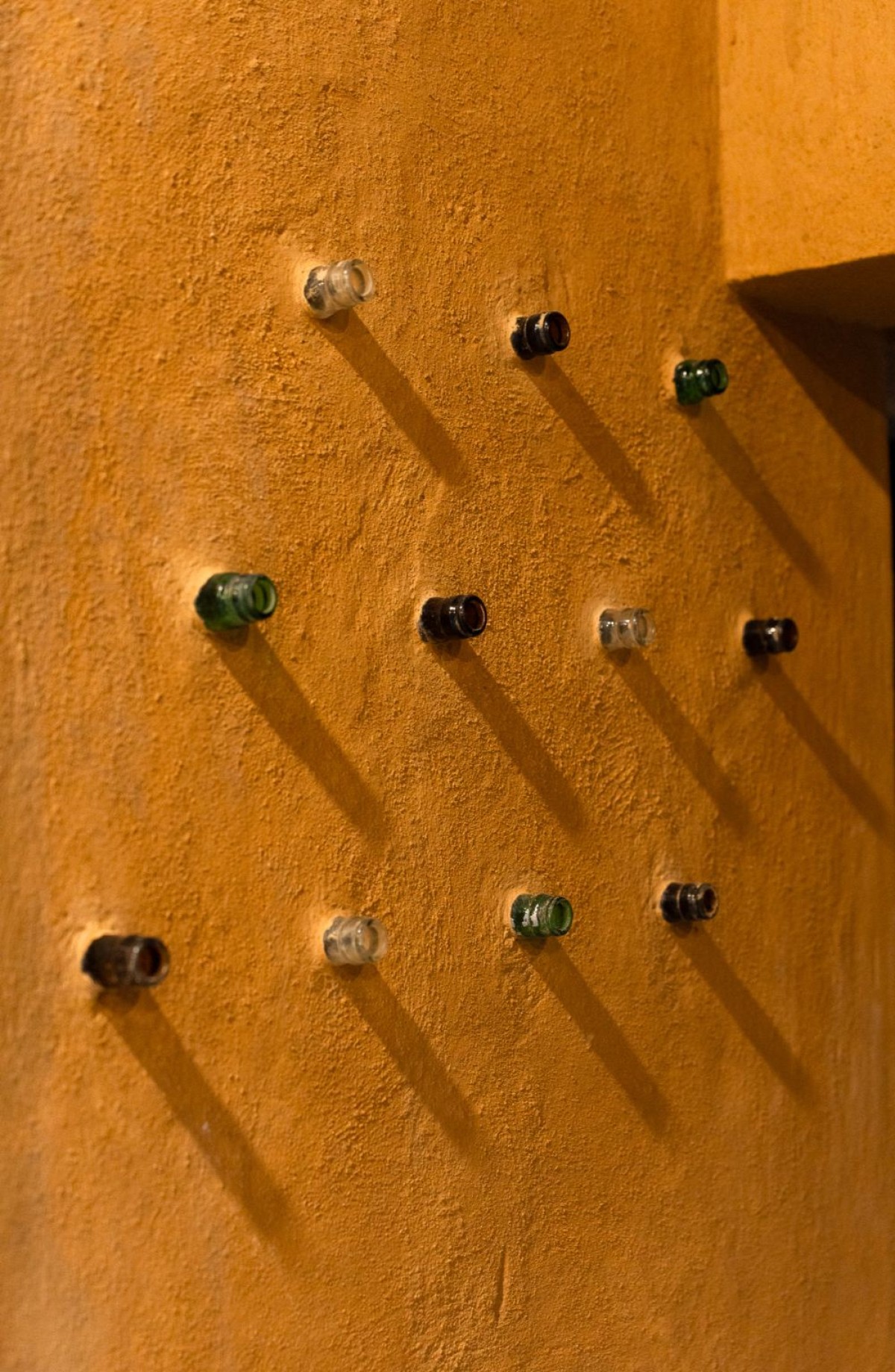 Detailed shot of recycled bottles wall of Composite Earth Farmhouse by Studio Verge