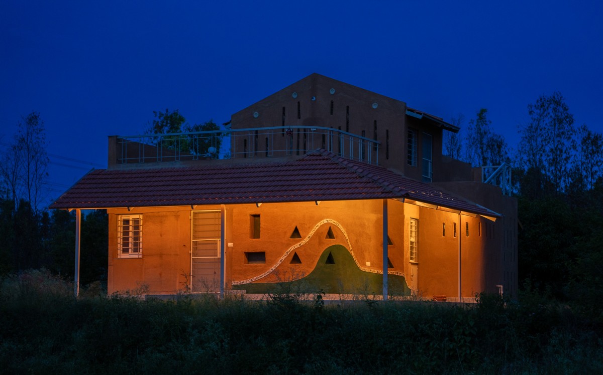 Dusk light exterior view of Composite Earth Farmhouse by Studio Verge