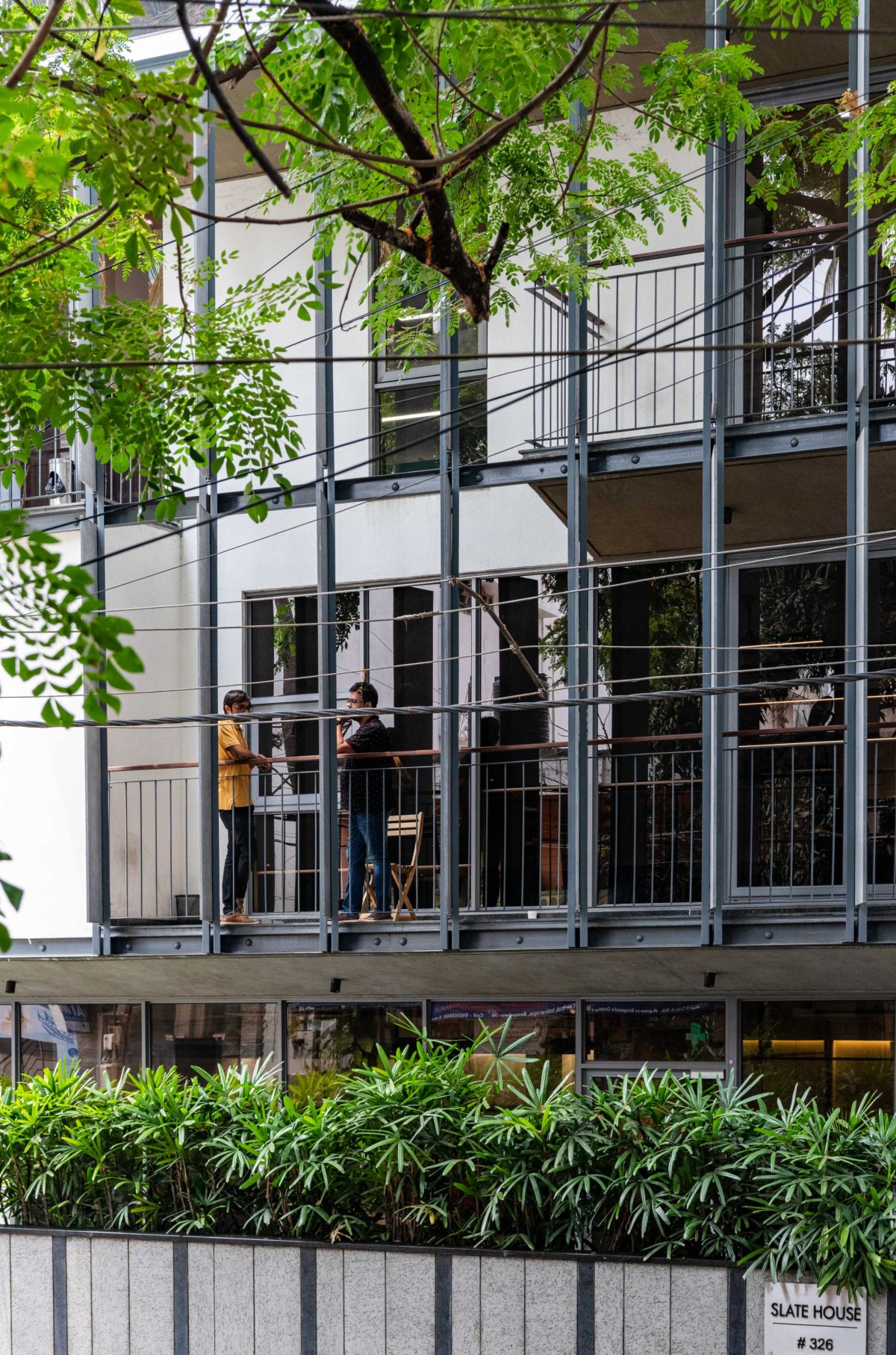 Visual connectivity achieved by staggered double-height balconies of Slate house by Funktion design