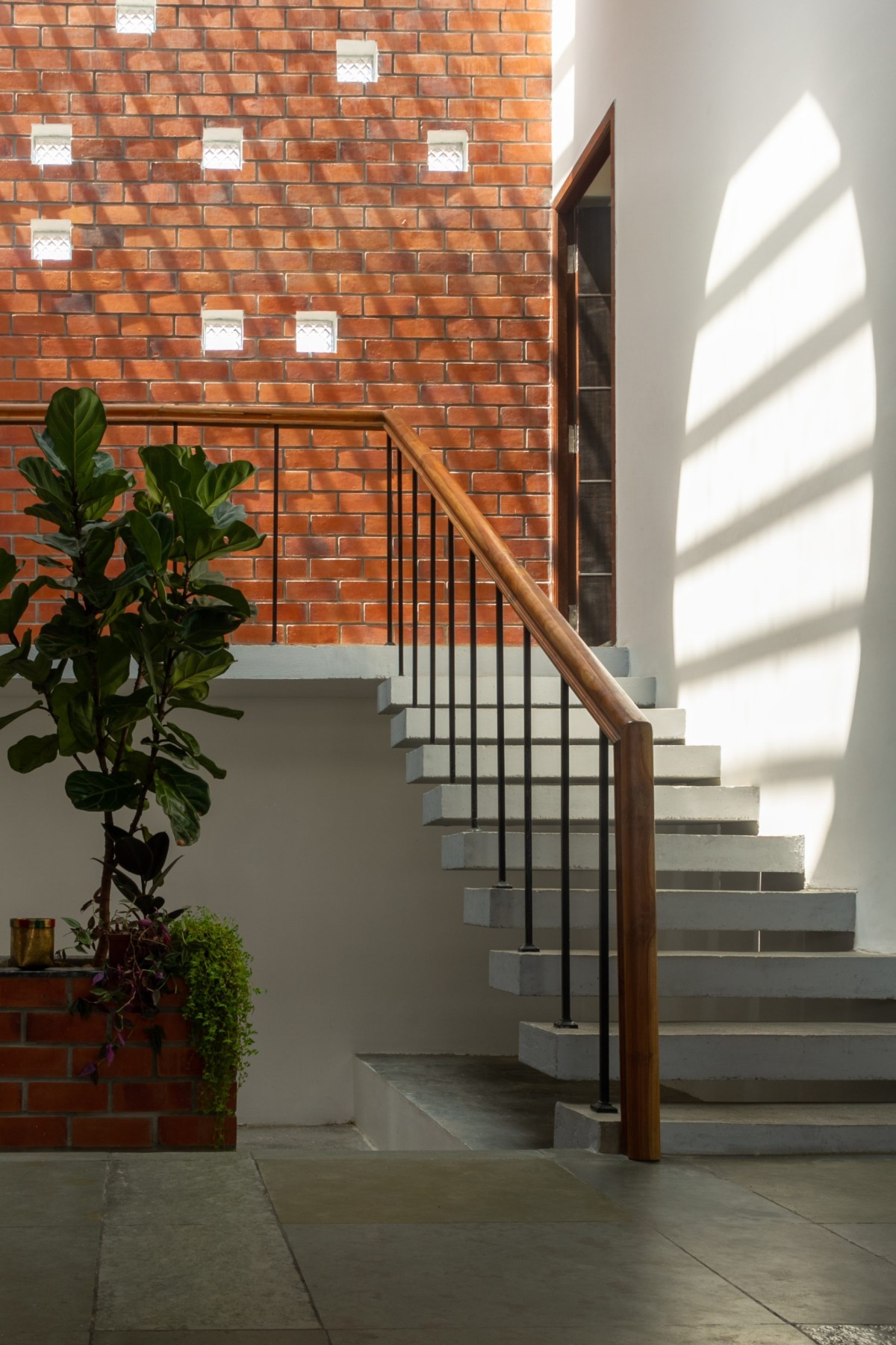 Central staircase court filled with filtered natural light through skylights and glass block windows