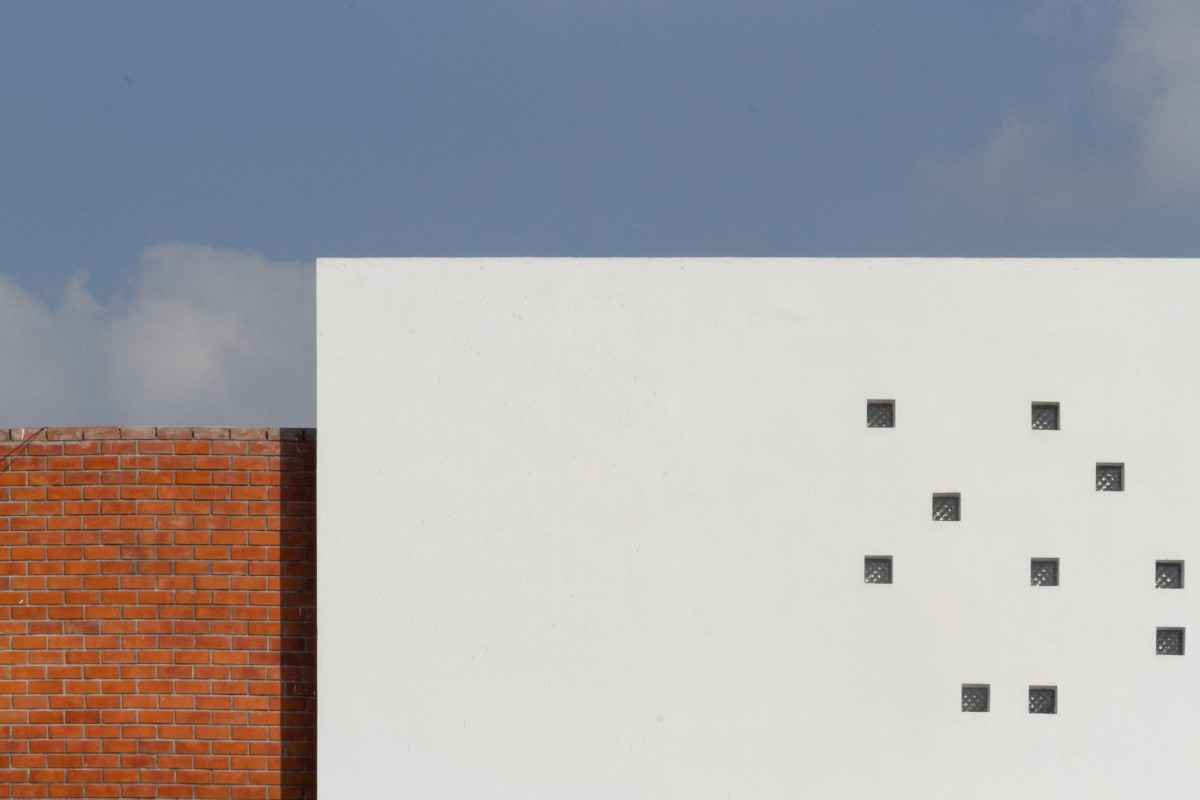 West-facing blank wall envelops exposed brick volume