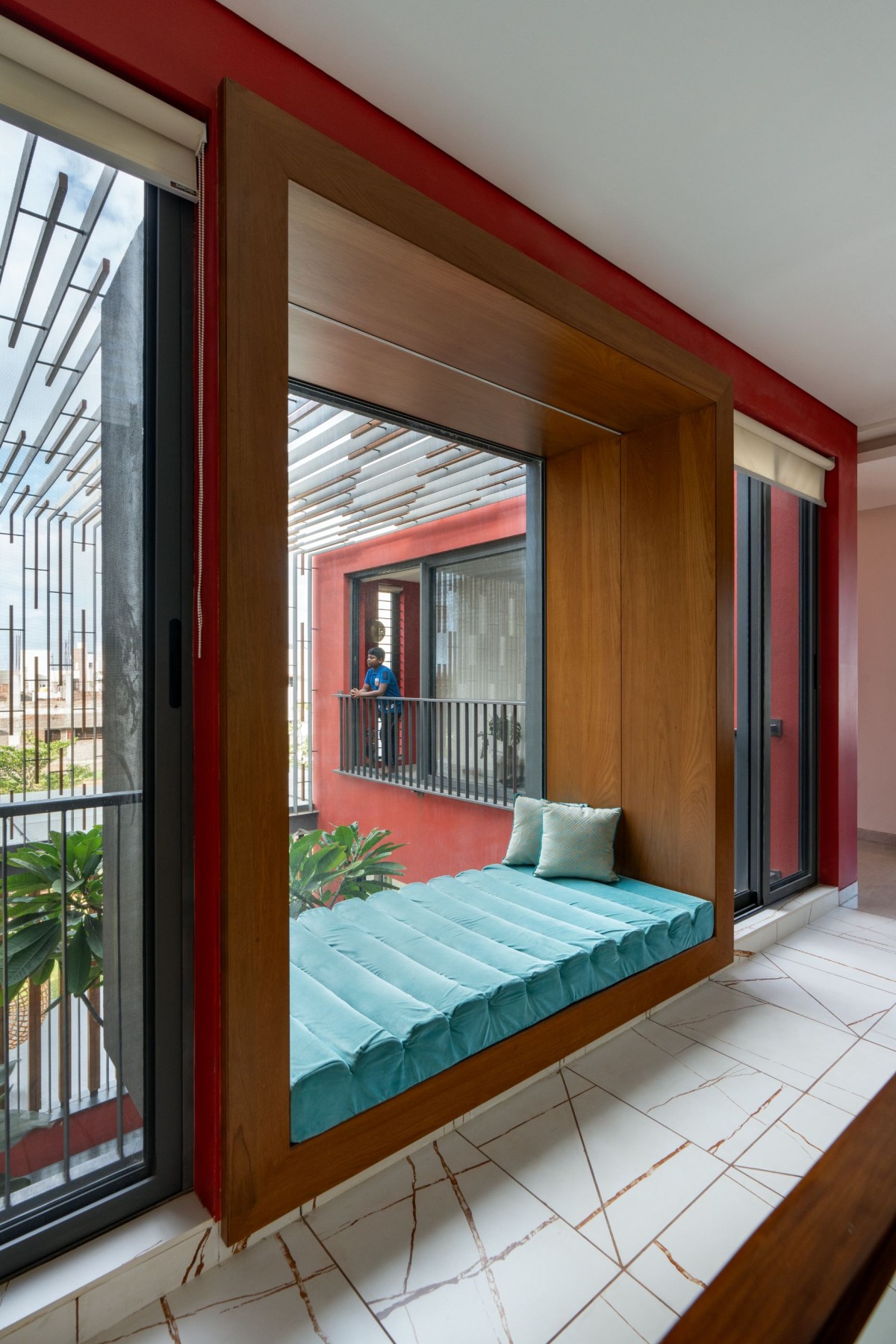 Day Bed with courtyard view of The Red Courtyard House by Jacob + Rathodi Architects