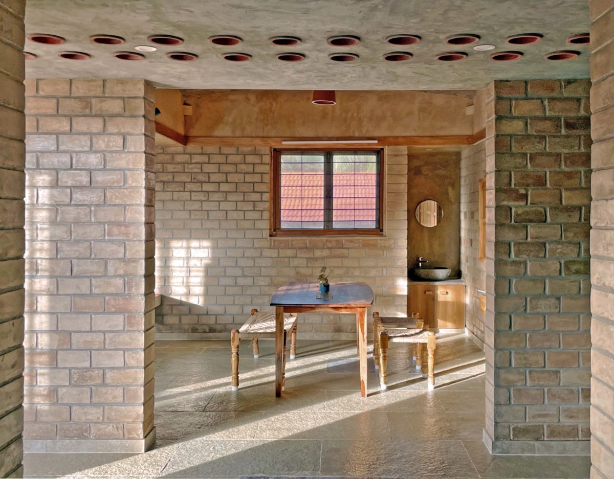 Filler slab roof framing the dining area  of Makizham Thottam by Second Ground