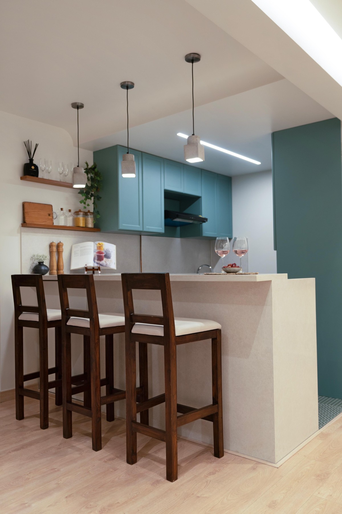 An open counter with solid wood bar stools of Maison Blanche by Oris Architects