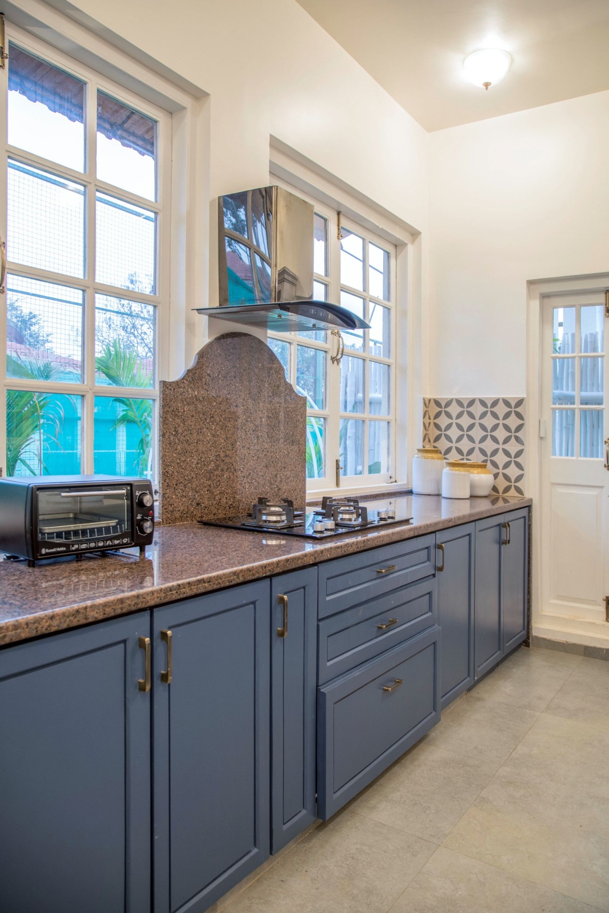 The kitchen is adorned in blue accents adding to the breezy charm of the villa