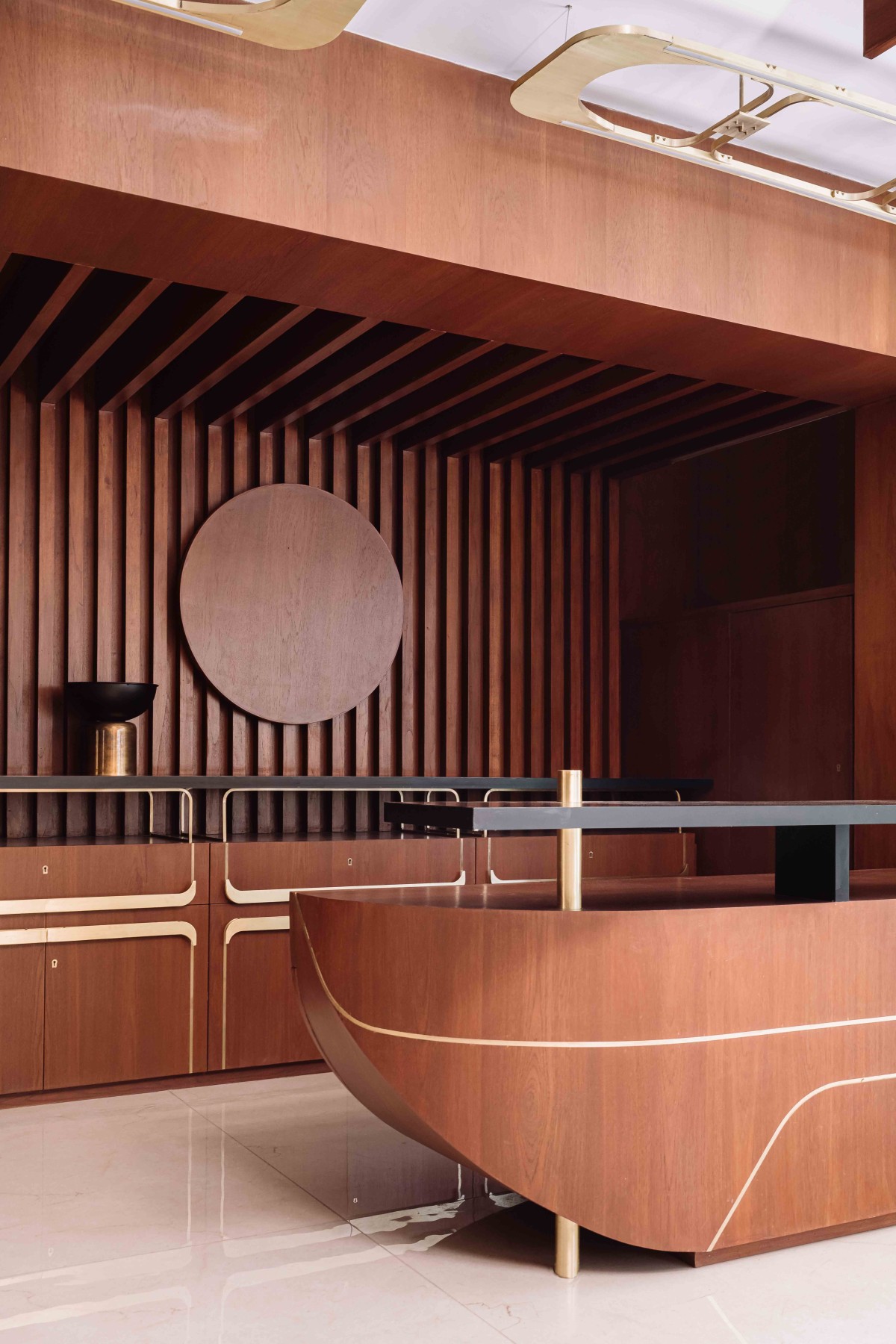 The reception table with brass inlay is accentuated by the wooden panelling in the backdrop
