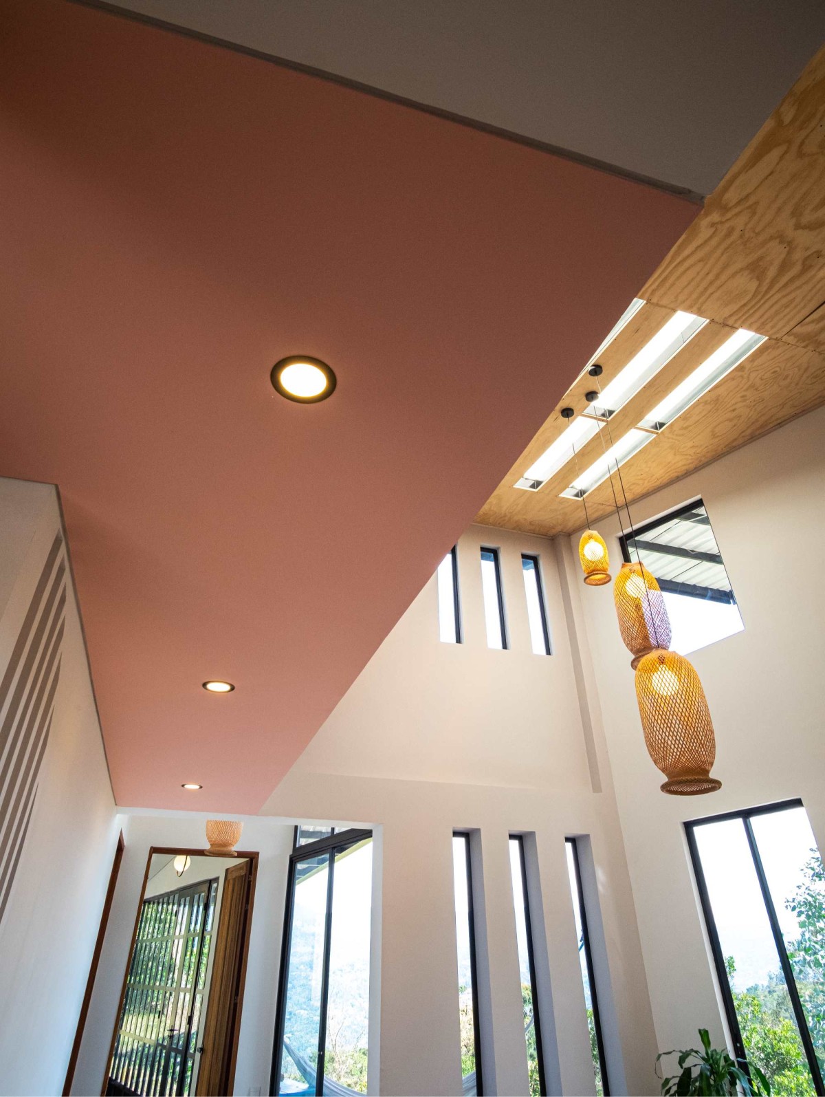 The slit windows continuing upwards as skylights, makes this the soul of the house. Enhancing the tall volumetric living space.