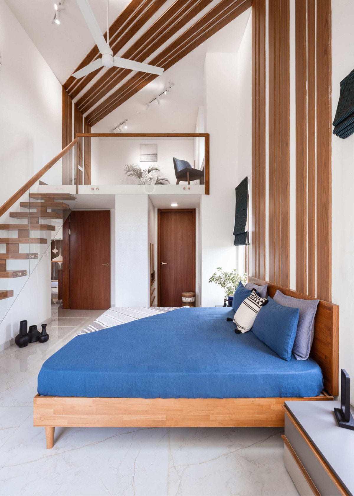 The cohesion of the wooden headboard from the lower level to the mezzanine creates panoramic visual experiences and merge the spaces seamlessly